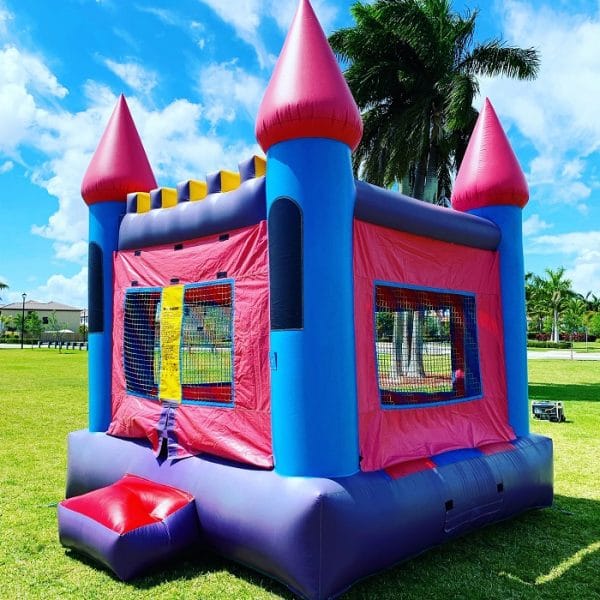 A pink and purple bounce house in the grass available for cheap party jumper rentals in Las Vegas.